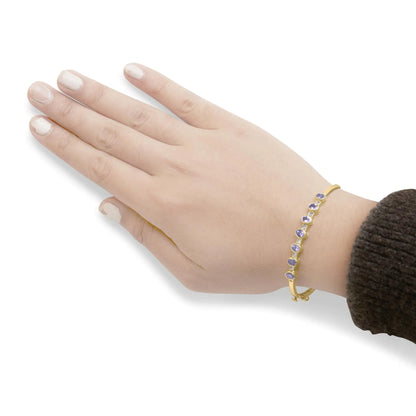 Brazalete de oro amarillo de 14 quilates con bisel alterno, tanzanita ovalada de 5 mm y diamantes de 1/5 quilates (color HI, claridad VS2-SI1). Se adapta a muñecas de hasta 7,25 pulgadas.